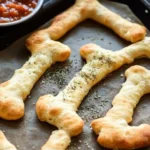 Cheesy Halloween Breadstick Bones served on a spooky-themed plate