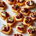 Delicious Cranberry Brie Bites on a serving platter garnished with herbs
