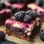 Delicious blackberry cheesecake brownies with a creamy cheesecake layer and fresh blackberries.