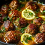 Plate of Greek meatballs served in a lemon sauce, garnished with herbs.